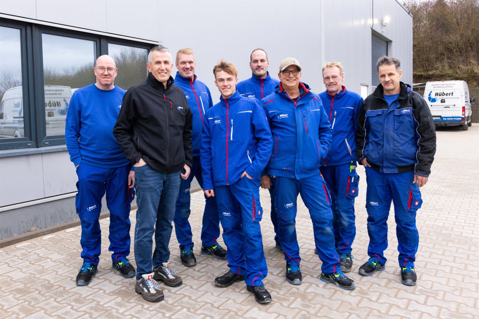 Gruppenfoto des technischen Außendienstteams von Hübert Gebäudetrocknung. Die Mitarbeitenden sorgen täglich für Leckageortung, Gebäudetrocknung und die fachgerechte Sanierung von Wasserschäden.